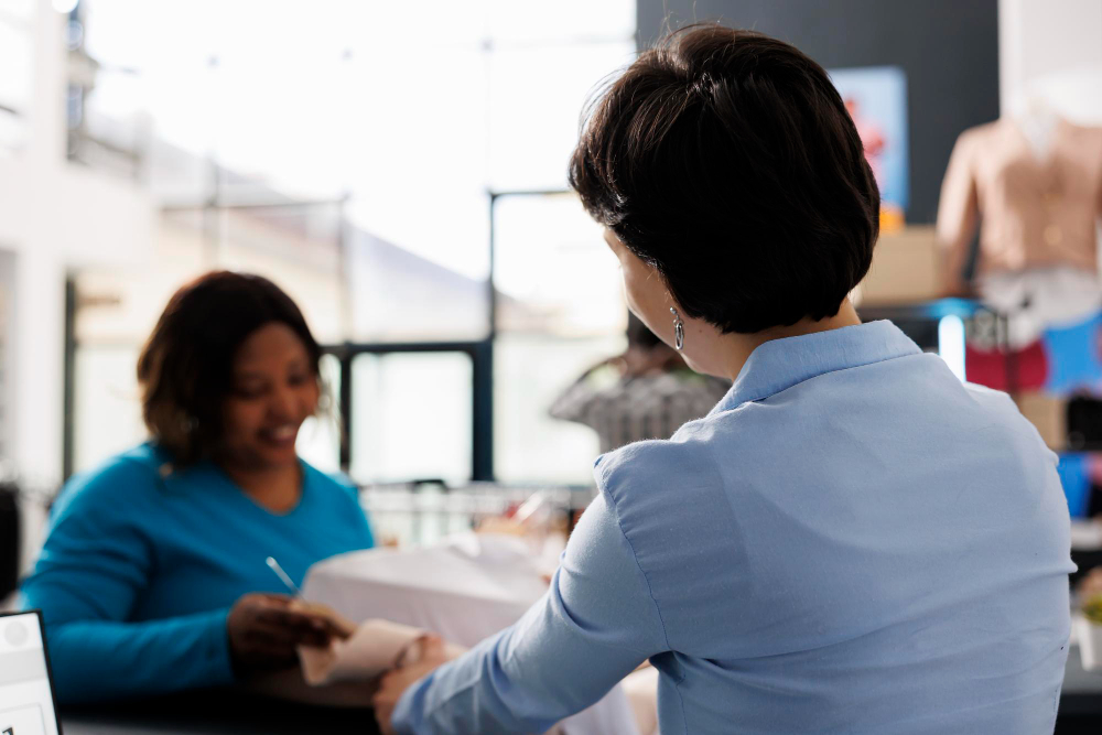 Two colleagues having supportive one-on-one conversation about compliance in the workplace and wellbeing